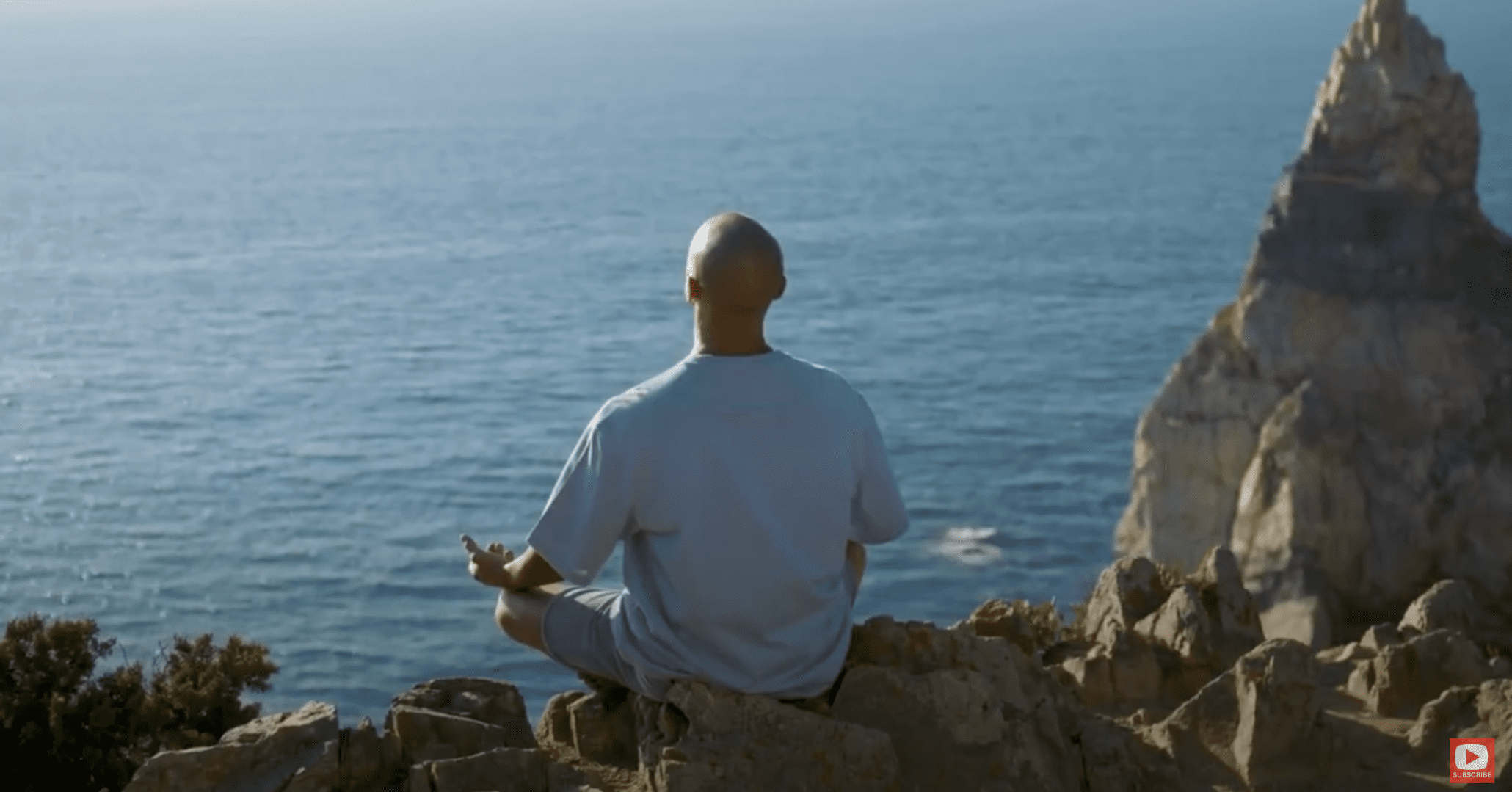 Man meditating next to ocean